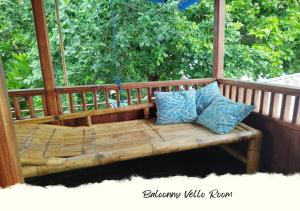 a wooden bench with pillows on a gazebo at HEINER HOMESTAY in Bunaken