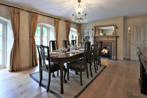 a dining room with a table and chairs and a fireplace at Rare Opportunity to stay on Unique Private Estate in Malahide