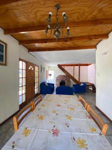 una grande sala da pranzo con un grande tavolo con sedie blu di Hermosa casa familiar para 8 personas con tinaja-Cochiguaz Valle de Elqui a Paihuano