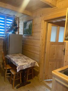 una cucina con tavolo in una cabina di legno di Zakątek w Dolinie a Łapszanka