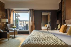 a bedroom with a large bed and a large window at Anantara New York Palace Budapest - A Leading Hotel of the World in Budapest