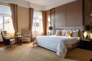 una camera da letto con un grande letto bianco e finestre di Anantara New York Palace Budapest - A Leading Hotel of the World a Budapest