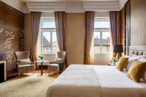 布達佩斯的住宿－Anantara New York Palace Budapest - A Leading Hotel of the World，酒店客房,配有一张床和两把椅子