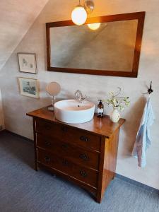 a bathroom with a sink and a mirror on a dresser at Skrea Backe Bo in Falkenberg