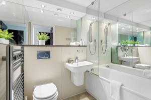 a bathroom with a sink and a toilet and a shower at Gorgeous Mile End Flat in London