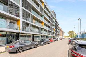 a row of cars parked in front of a building at Gorgeous Mile End Flat in London