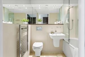 a bathroom with a toilet and a sink and a shower at Gorgeous Mile End Flat in London