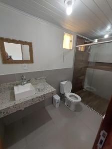 La salle de bains est pourvue d'un lavabo, de toilettes et d'une douche. dans l'établissement Casa em Frente ao Mar, à Prado