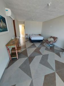 - une chambre avec un lit et un sol en damier dans l'établissement Casa em Frente ao Mar, à Prado