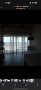 - une chambre avec un lit et une fenêtre avec des rideaux dans l'établissement Casa em Frente ao Mar, à Prado