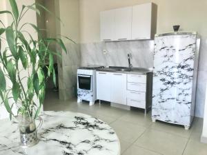 a kitchen with a refrigerator and a sink and a table at Departamento al lado de Fortis in Ciudad del Este