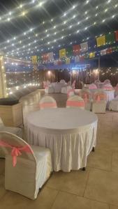 a room with white tables and chairs and lights at HOTEL PEARL WOOD (A unit of olive hospitality group) in Zirakpur