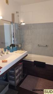 a bathroom with a sink and a tub and a mirror at Version SUD - Appartement vue sur mer in Toulon