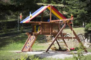 een houten speelplaats met een kleurrijk dak bij Agriturismo Rossolampone in San Bernardino Verbano