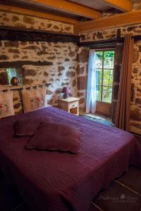 a bedroom with a purple bed in a room with a window at gîte "le seccadou" Ecuries de Saint Maurice in Lacapelle-Marival