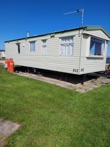 a white trailer is parked in a yard at Beautiful 2-Bed Wigwam in ingoldmells in Ingoldmells