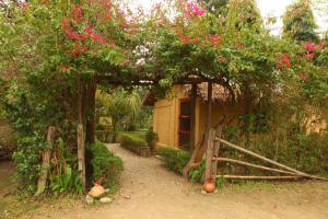 a garden with a gate and a house with flowers at Forest Hideaway Resort Pvt Ltd in Bhurkīā