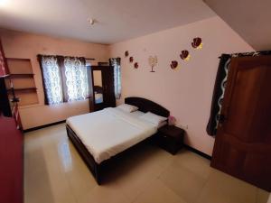 a bedroom with a bed and a window at Ooty Silver Wood Residency in Ooty