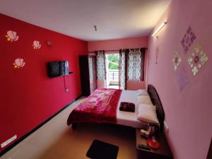 a bedroom with red walls and a bed in it at Ooty Silver Wood Residency in Ooty