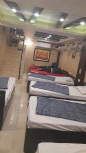 a row of beds in a room with stairs at Goroomgo Comfort Hostel Charbagh Lucknow Near Railway Station in Lucknow