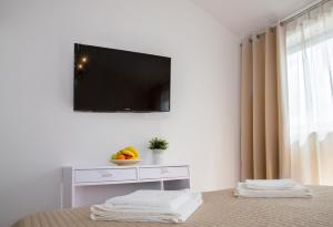 a living room with a television on a wall with a table at Apartment Victoria II in Dubrovnik