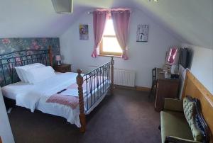a bedroom with a bed and a window at Carnately Lodge in Ballycastle