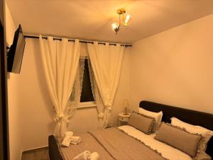 1 dormitorio con cama y ventana en Apartament Mahmudia - Casa Anastasia Murighiol en Mahmudia