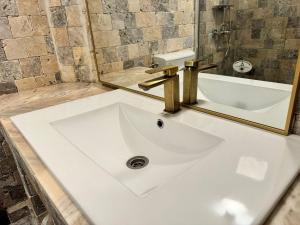 lavabo blanco en el baño con espejo en Apartament Mahmudia - Casa Anastasia Murighiol en Mahmudia