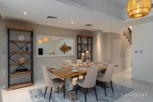 a dining room with a wooden table and chairs at Boho Inspired Large Luxury Villa in Dubai