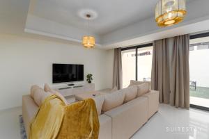 Boho Inspired Large Luxury Villa في دبي: غرفة معيشة مع أريكة كبيرة وتلفزيون
