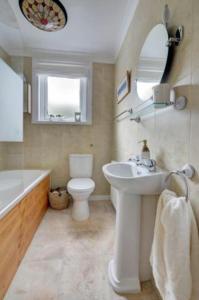 Un baño con lavabo, bañera e inodoro. en Lynton Exmoor Devon stylish comfy Edwardian house, en Lynton