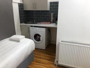 a small kitchen with a washing machine in a room at 36 King Star Hotel in London