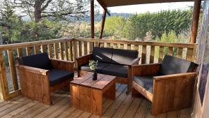 - une terrasse couverte avec 2 chaises et une table basse dans l'établissement Tente Lodge au Domaine de l'Aven, à Villeneuve-Minervois