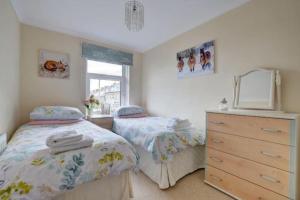 1 dormitorio con 2 camas, vestidor y ventana en Lynton Exmoor Devon stylish comfy Edwardian house, en Lynton