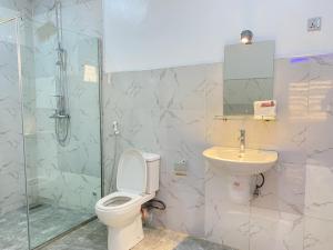 a bathroom with a toilet and a sink and a shower at The Seasons Apartment Kado in Abuja