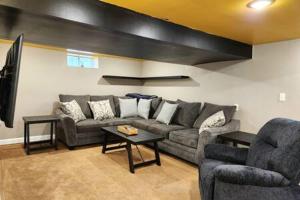 ein Wohnzimmer mit einem Sofa und einem Tisch in der Unterkunft Large Cozy House Near NexusPark Air Hockey in Columbus