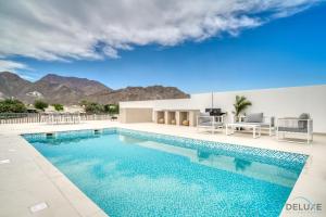 a swimming pool with a view of the mountains at Beautiful 3BR Villa with Assistant Room Al Dana Island, Fujairah by Deluxe Holiday Homes in Fujairah