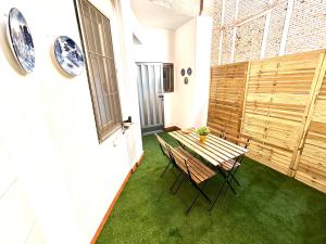 einen kleinen Balkon mit einem Tisch und Stühlen auf grünem Gras in der Unterkunft Torre de Romo - Más que apartamentos in Murcia