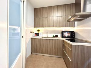 eine Küche mit einer Spüle und einer Mikrowelle in der Unterkunft Torre de Romo - Más que apartamentos in Murcia