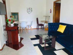 ein Wohnzimmer mit einem blauen Sofa und einem Tisch in der Unterkunft Naisiae - Lovely 1-bedroom vacation home with pool in Johannesburg