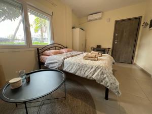a bedroom with two beds and a table and a window at Cozy Corner in Alexandroupoli