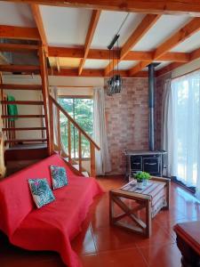 a living room with a red couch and a fireplace at Casa comoda in Villarrica