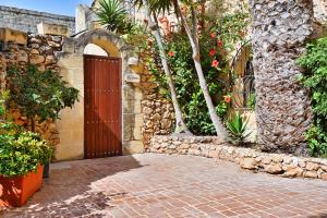 a brick walkway with a wooden door in a building at Ta'Peppa in Xagħra