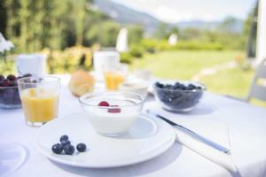a table with a bowl of fruit and a plate of food at Agriturismo Rossolampone in San Bernardino Verbano