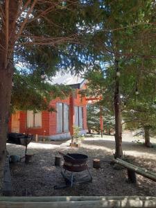 a fire pit in front of a building with trees at Casa comoda in Villarrica