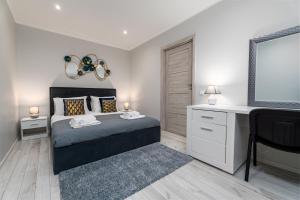 a bedroom with a bed with a desk and a tv at Stylish Apartment For up to 4 Guests With WiFi, Free Parking in Vilkaviškis
