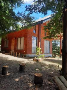 ein orangefarbenes Gebäude mit Bäumen davor in der Unterkunft Casa comoda in Villarrica