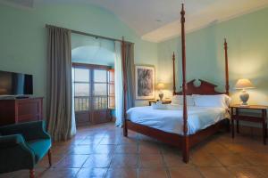 1 dormitorio con cama con dosel y balcón en Hotel Tugasa Castillo de Castellar en Castellar de la Frontera