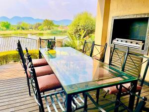 a glass table and two chairs on a deck at Mountainview Villa in Hartbeespoort