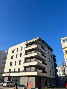 wysoki budynek apartamentowy z ludźmi idącymi przed nim w obiekcie Vila Drina Apartments w mieście Banja Koviljača